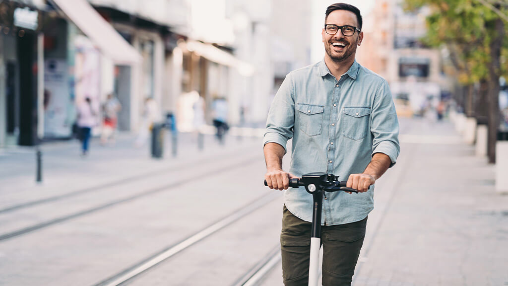 Homme qui se déplace en trottinette électrique.