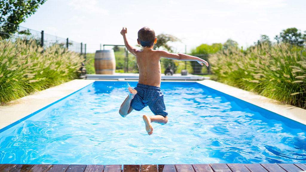 jeune garçon qui saute dans la piscine