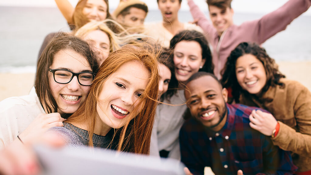 Groupe de jeunes gens heureux prenant un selfie