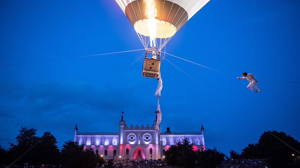 spectacle de nuit avec des acrobates aériens et une montgolfière