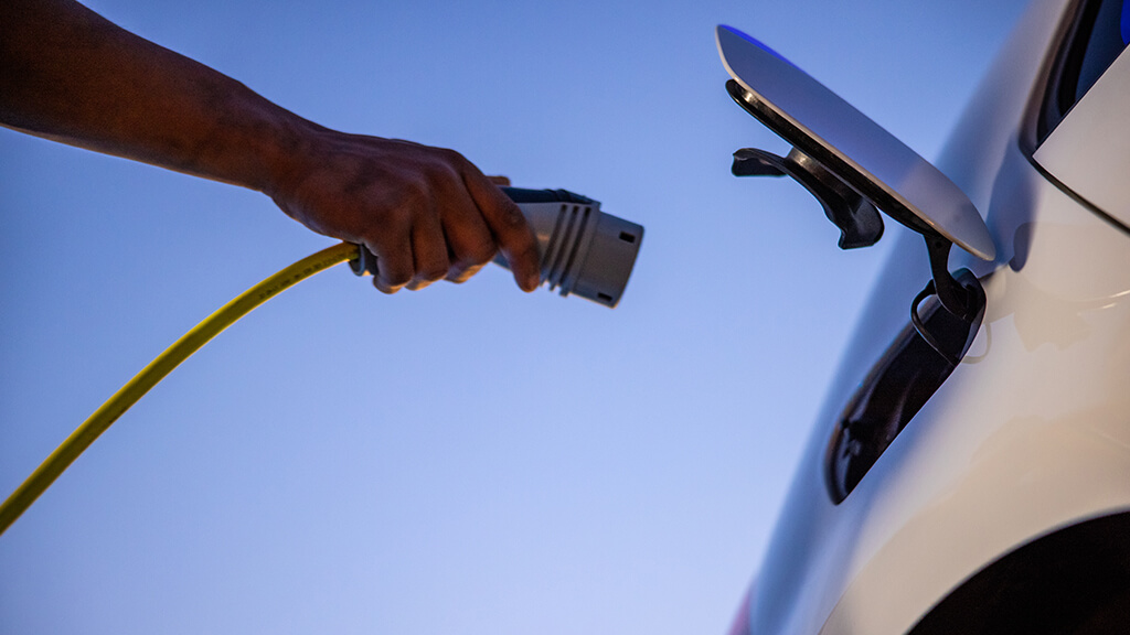 Une personne qui recharge sa voiture électrique