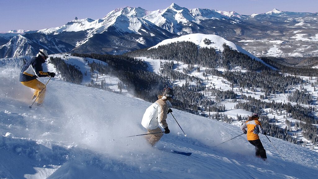 Drei junge Menschen, die im Hochgebirge Ski fahren